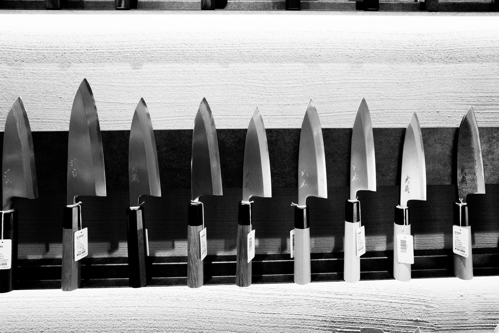 A row of traditional Japanese knives with wa handles in a knife shop